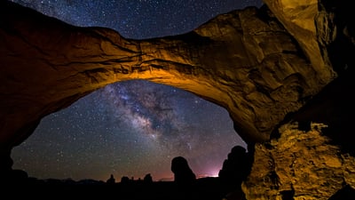 Bing wallpaper May 3, 2025. The Milky Way framed by Double Arch in Arches National Park, Utah (© Adventure_Photo/Getty Images)